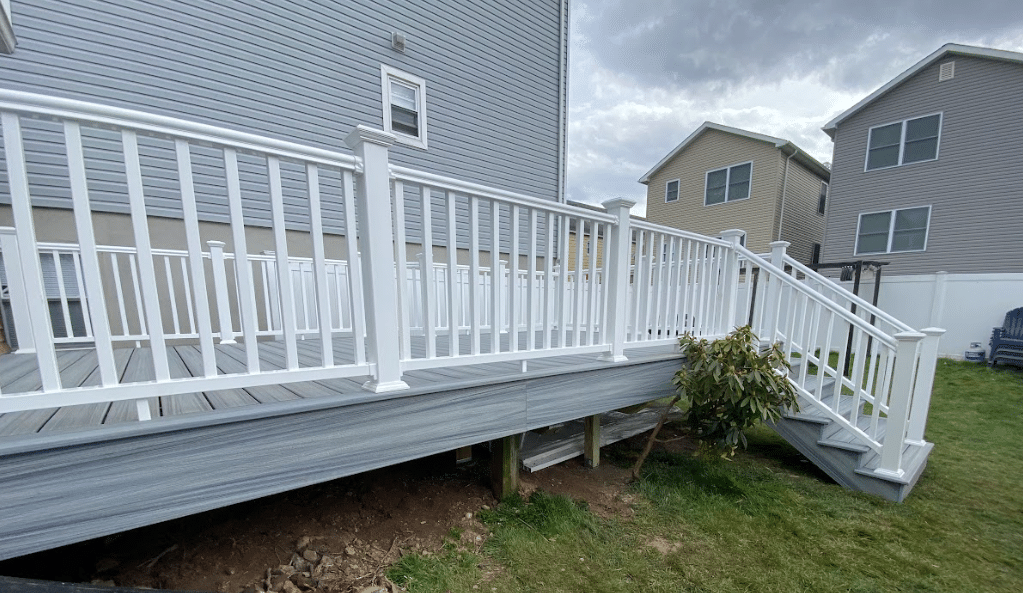 photo of a custom deck with white railing and steps