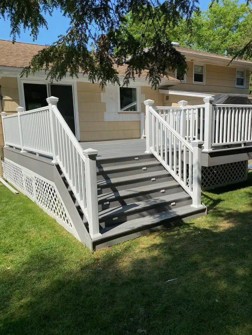 Gray composite deck with white railings and wide staircase.