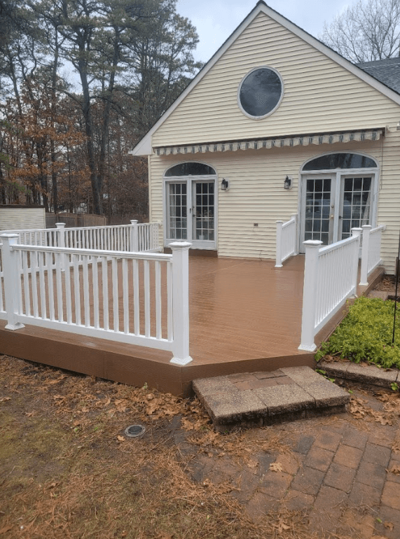 Photo of a new composite deck in Bayville, NJ, with a small accessibility ramp leading to the back door.