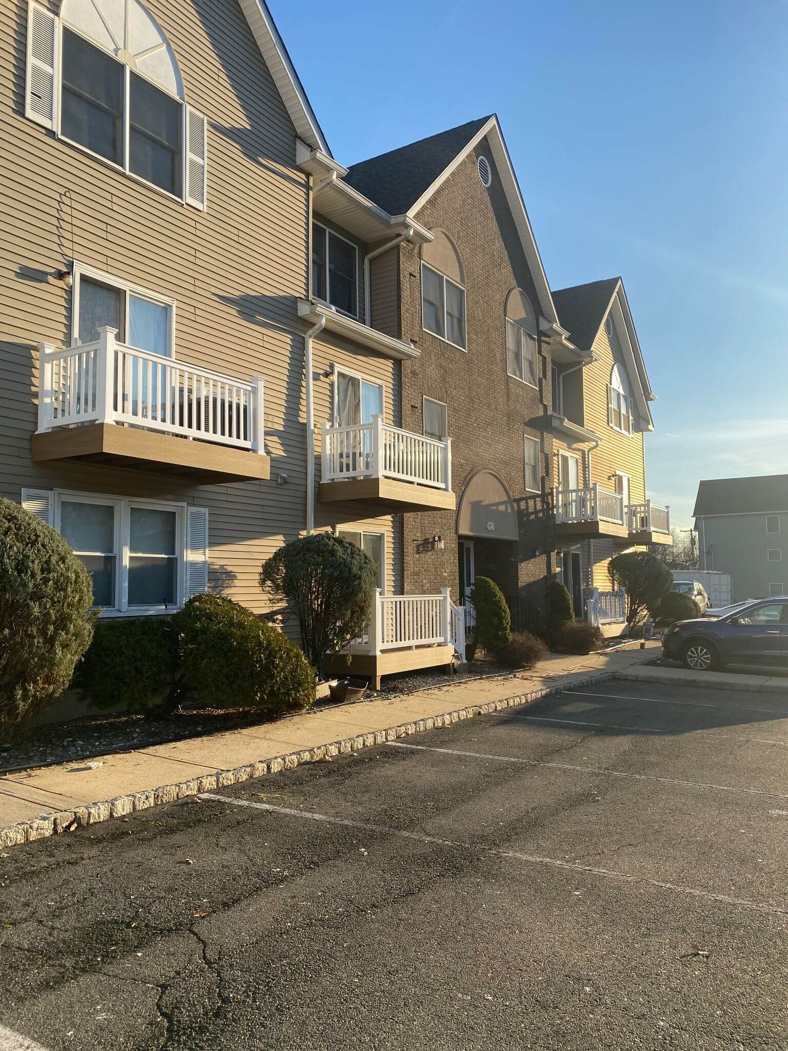 Apartment building featuring new balcony deck with white vinyl railing.