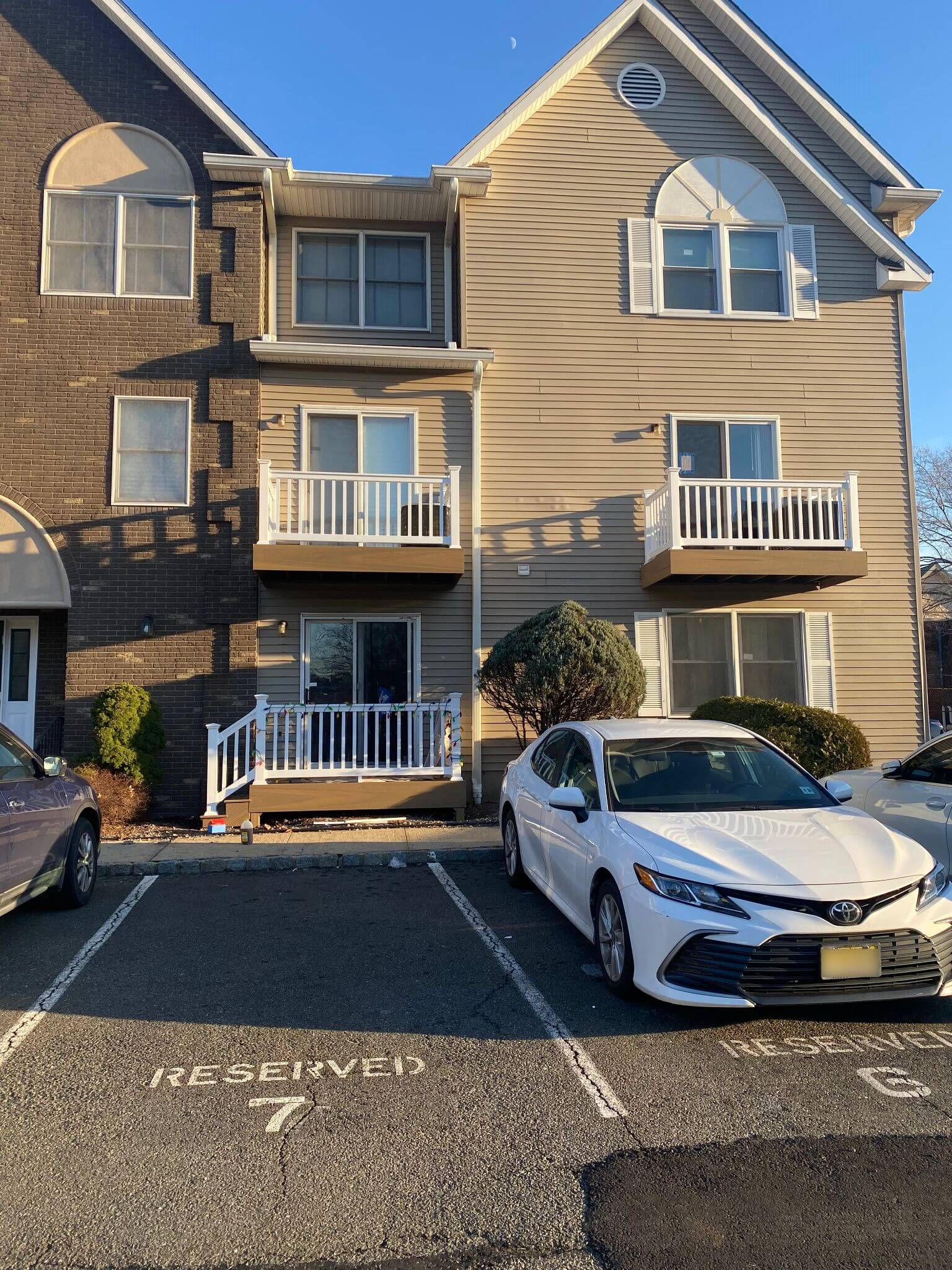 Apartment building with new balcony decks and white vinyl railing.