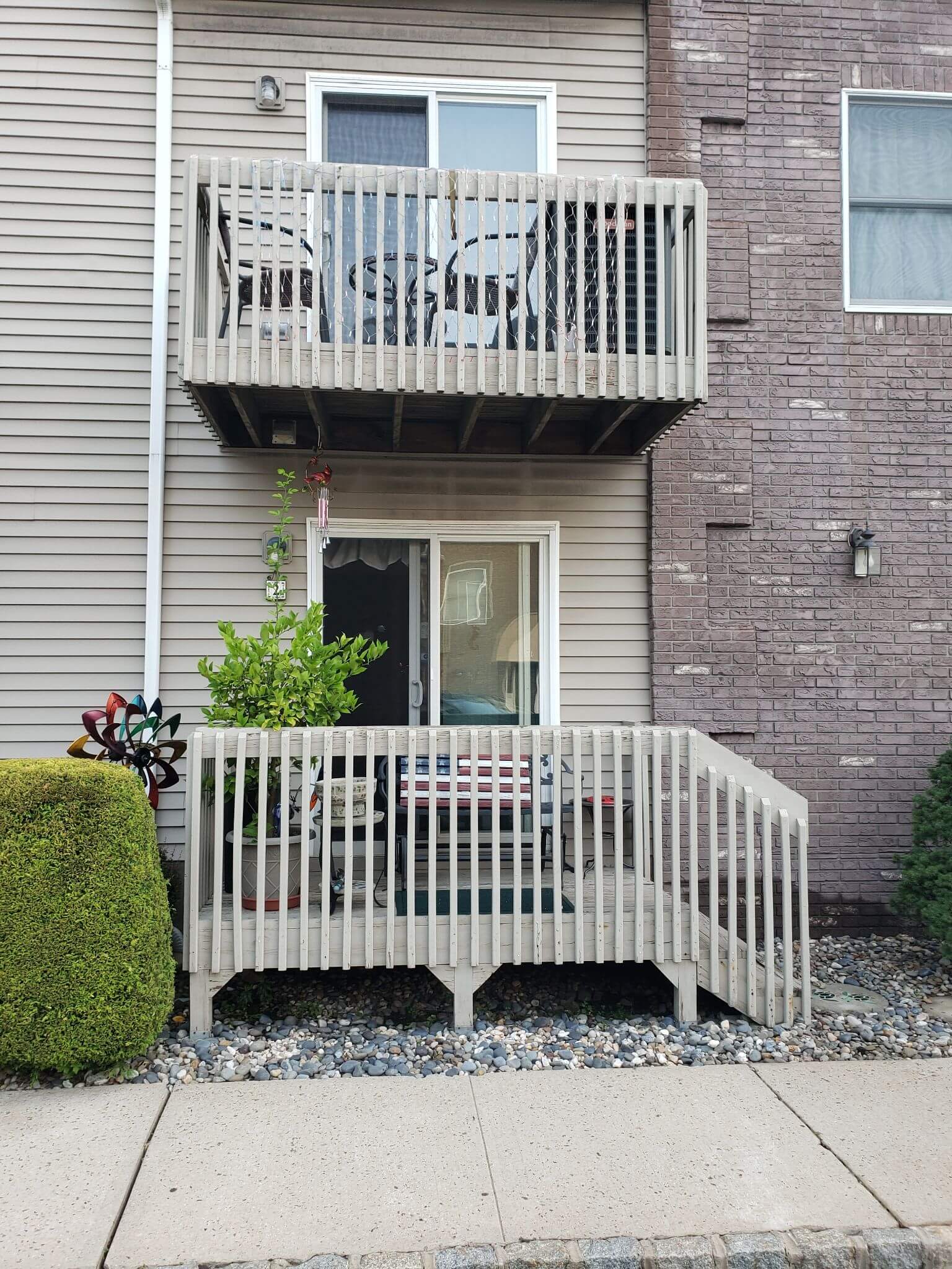 Exterior view of a residential building with old balcony decks that will be replaced