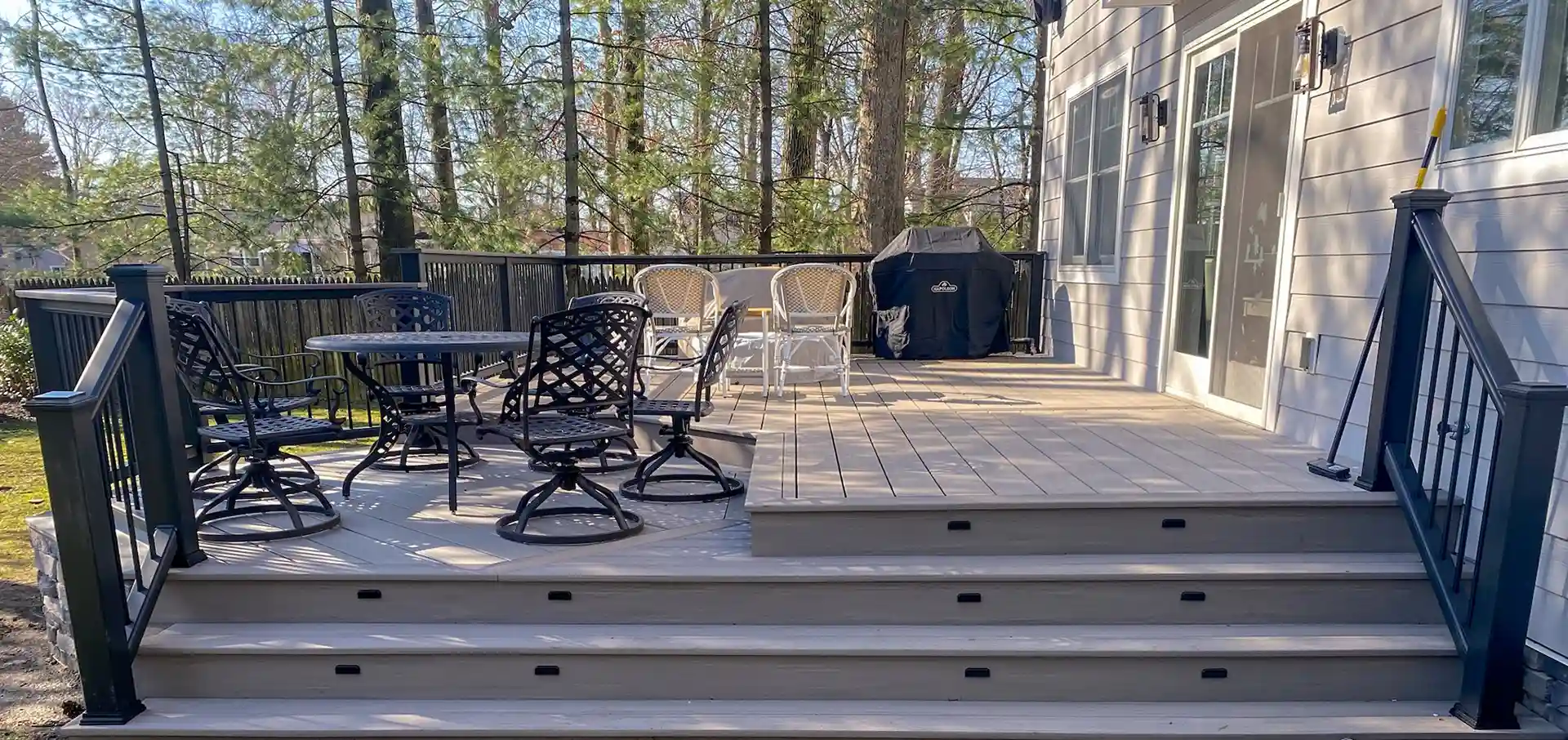 photo of a multi-level deck with distinct zones for relaxing, cooking, and outdoor dining - Deck Remodelers near me in New Jersey