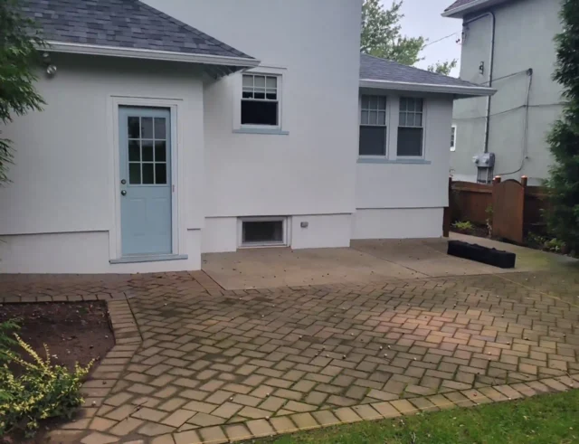 Ground-level patio with paver stones at the back of a house.