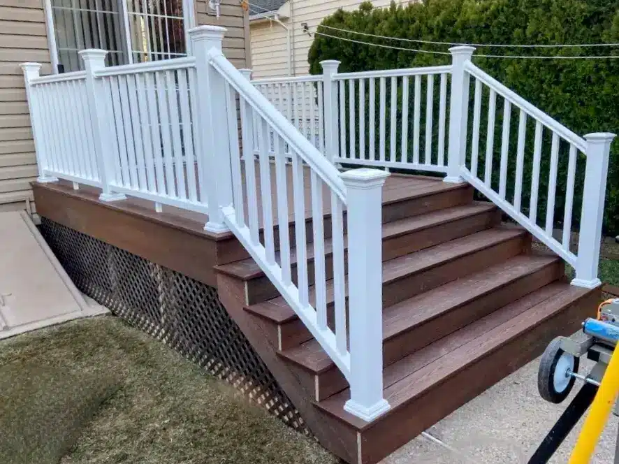 Elegant composite deck with rich brown flooring and crisp white railings, offering a stylish and durable outdoor entryway.