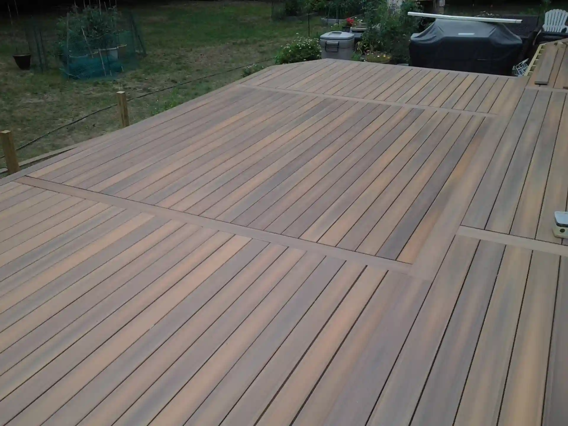 Composite deck with multi-directional board pattern in a natural wood finish.
